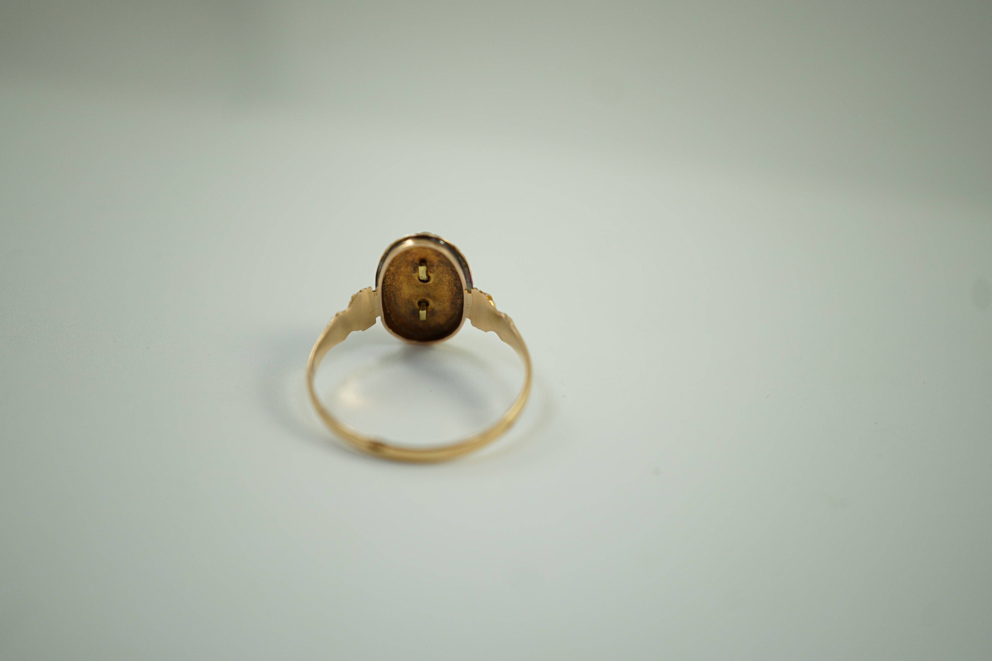 An early 20trh century French yellow metal (18ct poincon mark) and seed pearl cluster set oval ring, size N, gross weight 2.1 grams.